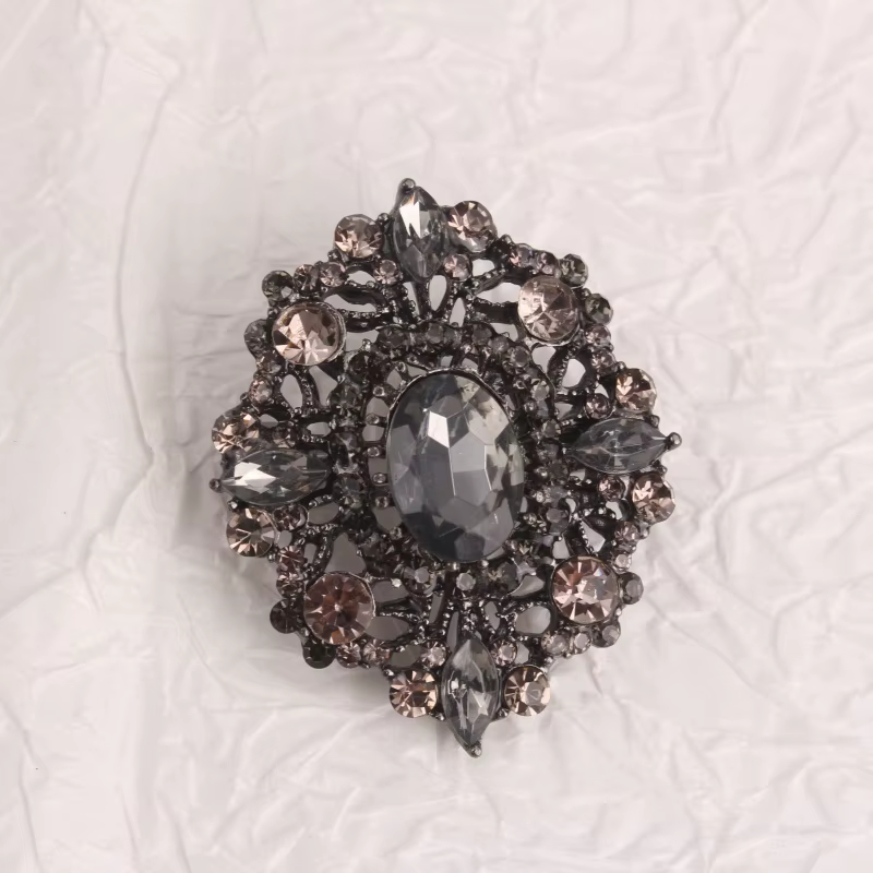 Broche de style vintage, base en métal avec cristaux foncés, magnifique broche avec design creux orn