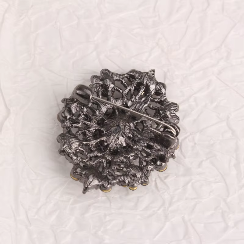 Broche de style vintage, base en métal avec cristaux foncés, magnifique broche avec design creux orné, idéale pour la décoration de manteau et de robe